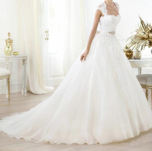 wedding photo - White colored wedding gown with heavy flair at the bottom.
